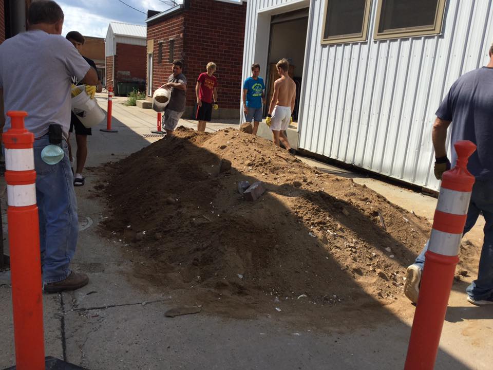 Greene County Rams help remove debris from basement of downtown building with a bucket brigade.